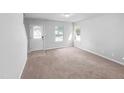 Bright living room featuring fresh paint, new carpet, a front door, and plenty of natural light at 2705 Ramblegate Ln, Durham, NC 27705