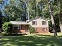 Charming two-story home with red brick and light yellow siding, complemented by lush greenery and a well-manicured lawn at 3205 Broyhill Cir, Raleigh, NC 27604