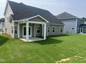 A spacious backyard features lush green grass, a covered patio with white columns, and well-maintained landscaping at 33 Black Walnut Dr # 185, Garner, NC 27529