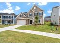 Charming two-story home featuring a stone facade, two-car garage, and a well-manicured lawn at 33 Black Walnut Dr # 185, Garner, NC 27529