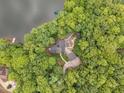 Aerial shot of the home nestled within a dense forest, boasting a serene lakeside setting at 343 Lakewood Pointe Dr, Roxboro, NC 27574