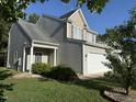 Exterior side view featuring a home with a two-car garage and front porch at 4009 Patriot Ridge Ct, Raleigh, NC 27610