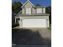 Home featuring a two-car garage, gray siding, and complementary brown accents at 4009 Patriot Ridge Ct, Raleigh, NC 27610