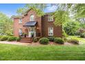 Charming brick two-story home featuring a well-manicured lawn and a welcoming front entrance with a black awning at 441 Fieldstone Dr, Burlington, NC 27215