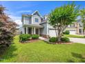 Charming two-story home with manicured lawn, flowering trees, and a welcoming front porch at 4502 Joe Cotton Dr, Knightdale, NC 27545