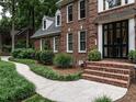 Brick home featuring a detailed walkway with lush landscaping leading to a dark front door at 4716 Shadow Ridge Ct, Holly Springs, NC 27540
