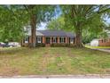 Charming brick home featuring a lush green lawn and mature trees at 5110 Old Well St, Durham, NC 27704