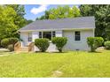 Single story home with brick siding and a spacious lawn, surrounded by lush trees at 605 E Montgomery St, Henderson, NC 27536