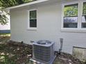 A new AC unit sits below a freshly painted house with white trim around the window at 605 E Montgomery St, Henderson, NC 27536