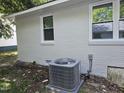 A new AC unit sits below a freshly painted house with white trim around the window at 605 E Montgomery St, Henderson, NC 27536