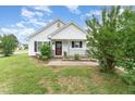 Lovely single-story house boasting a quaint porch, well-maintained garden, and appealing exterior at 606 Arden St, Burlington, NC 27215