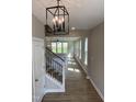 Inviting entryway with hardwood floors, an elegant chandelier, and stairs with black metal railings at 61 Black Walnut Dr # 188, Garner, NC 27529
