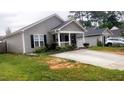 Charming single-story home featuring a welcoming front porch and a well-maintained landscaped yard at 764 Grove Creek Ln, Raleigh, NC 27610