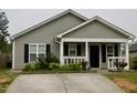 Close up of an attractive single-story house with gray siding, a front porch, and a concrete driveway at 764 Grove Creek Ln, Raleigh, NC 27610