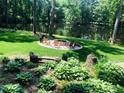 Peaceful backyard with a lake view, Adirondack chairs around a fire pit, and beautiful landscaping at 8620 Glendale Dr, Apex, NC 27539
