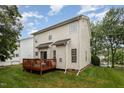Back exterior with a wooden deck, sliding glass doors, and neutral siding under a partly cloudy sky at 109 Troyer Pl, Apex, NC 27502