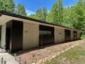 Modern home exterior featuring clean lines, neutral colors, and natural landscaping against a wooded backdrop at 1115 Sepelo Way, Efland, NC 27243