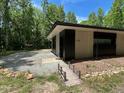 Unique home exterior with modern design, well-maintained landscaping, and a serene wooded backdrop at 1115 Sepelo Way, Efland, NC 27243