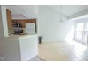 Open kitchen and dining area with tile flooring and ample natural light at 115 Abingdon Ct # 2B, Cary, NC 27513