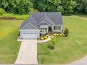 Aerial view of a well-kept single-Gathering home with a green lawn, mature trees, and a long driveway at 115 Jensen Dr, Wendell, NC 27591