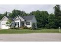 Gray home with a manicured lawn, complemented by tasteful landscaping and an attached two-car garage at 115 Jensen Dr, Wendell, NC 27591