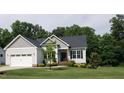 Beautifully designed home with a landscaped front yard, featuring a two-car garage and attractive gray siding at 115 Jensen Dr, Wendell, NC 27591