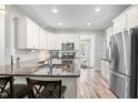 Well-lit kitchen featuring granite countertops, stainless steel appliances, and stylish white cabinets at 115 Jensen Dr, Wendell, NC 27591