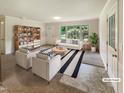Bright living room with modern furniture, large window, and stylish decor accents at 1413 Chamblee Rd, Zebulon, NC 27597