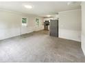 Open floor plan with living area leading to kitchen, stainless steel appliances and bright lighting at 1413 Chamblee Rd, Zebulon, NC 27597