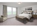 Serene main bedroom with large window, neutral color palette, carpet flooring, and coordinating bedside tables and lamps at 153 Gladstone Loop, Clayton, NC 27520