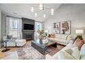 Elegant living room featuring a fireplace, sleek furniture, abstract art, and large windows for ample natural light at 16 W Currituck Cir, Garner, NC 27529
