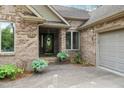 Charming brick home featuring a quaint front entrance with decorative plants and a welcoming wreath on the door at 174 Woodwedge Way, Sanford, NC 27332