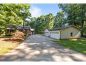 Long concrete driveway to the house and detached garage with three car garage bays at 1973 Elon Ossipee Rd, Elon, NC 27244