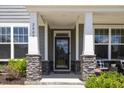 Charming front porch with stone pillars, seating, and a view of the manicured lawn at 2009 Latham Oaks Ave, Wake Forest, NC 27587