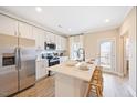 Elegant kitchen featuring an island with seating, white cabinets, and stainless steel appliances at 219 Broomgrove Way, Wake Forest, NC 27587