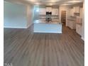 Open concept living area with a kitchen island featuring granite countertops and modern appliances at 224 Wild Turkey Way, Lillington, NC 27546