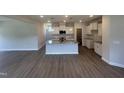 Well-lit kitchen featuring a large island with granite countertops, modern appliances, and stylish pendant lighting at 224 Wild Turkey Way, Lillington, NC 27546