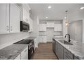 Well-equipped kitchen with stainless steel appliances, granite counters, central island, and gray cabinets at 224 Wild Turkey Way, Lillington, NC 27546