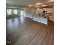 Spacious open-concept living area featuring wood-look flooring, natural light, and modern kitchen at 224 Wild Turkey Way, Lillington, NC 27546