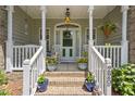 Inviting front porch with rocking chairs, potted plants, and a decorative door, creating a warm welcome at 229 Hocutt Farm Dr Dr, Clayton, NC 27527