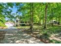 Traditional home and detached garage with a spacious driveway nestled among mature trees at 25 Misty Way, Franklinton, NC 27525