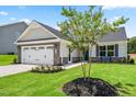 Beautiful new home with manicured lawn, stone accents, two car garage, and a young crape myrtle tree at 30 Elmwood Ave, Sanford, NC 27330