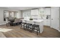 Well-lit kitchen and dining area featuring a large island with bar stools and hardwood floors at 32 Elmwood Ave, Sanford, NC 27330
