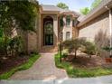 Elegant brick home with arched entryway, double doors, and meticulously maintained landscaping at 540 Vista Del Lago Ln, Wake Forest, NC 27587