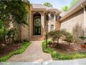 Elegant brick home with arched entryway, double doors, and meticulously maintained landscaping at 540 Vista Del Lago Ln, Wake Forest, NC 27587