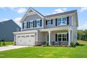 Charming two-story home featuring a two-car garage, well-manicured lawn, and inviting blue front door at 60 Lismore St, Sanford, NC 27330