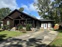 Log cabin home with a long driveway, showcasing its rustic charm and curb appeal at 603 Hugo St, Durham, NC 27704
