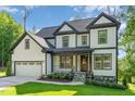 Beautiful home featuring black-framed windows, a manicured lawn, and an attached two-car garage at 66 Sweet Meadow Ln, Pittsboro, NC 27312