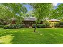 Charming home exterior with mature landscaping and lush green grass, offering a welcoming curb appeal and a serene setting at 6971 Shady Creek Trl, Rougemont, NC 27572