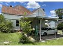 Rear exterior of home featuring a carport with a white car parked underneath and side yard at 705 Washington St, Graham, NC 27253